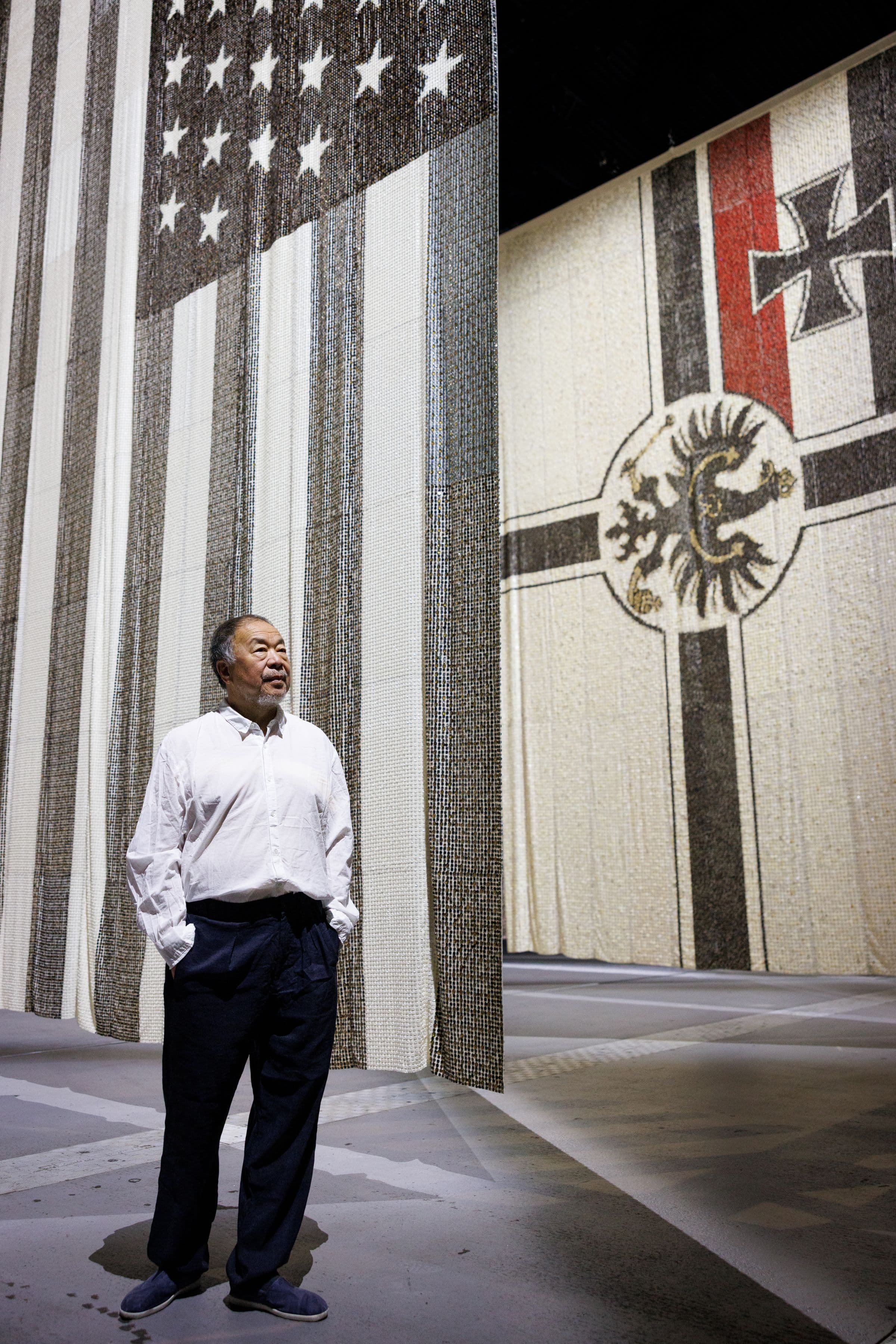 Ai Weiwei standing inside a large gallery installation at Factory International.