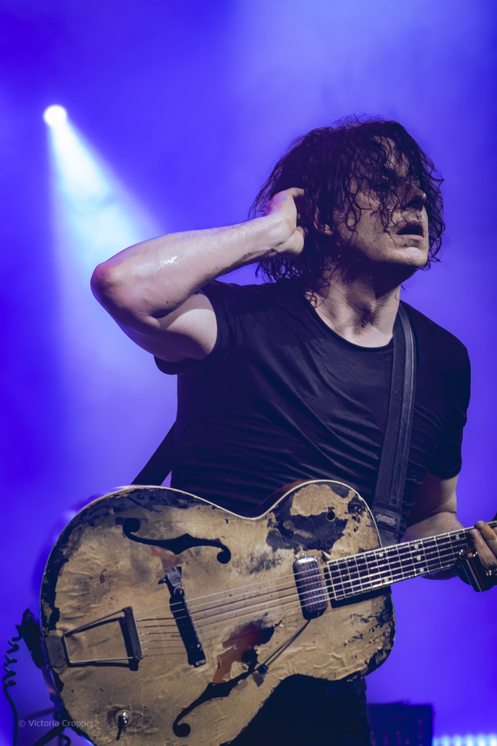 Jack White performing live at O2 Academy Liverpool under blue and purple stage light.