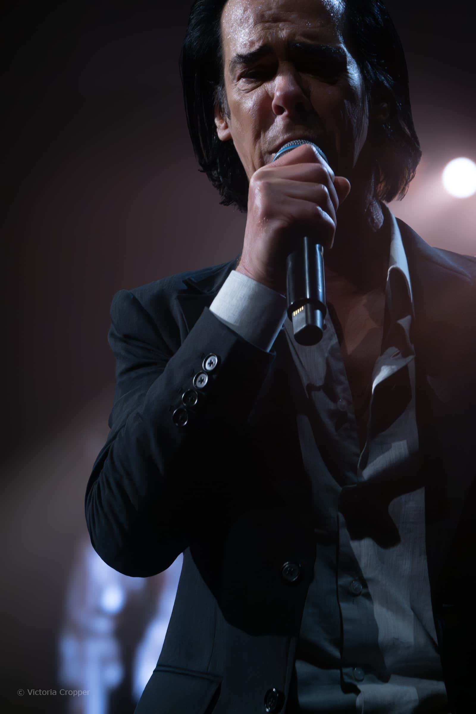 Nick Cave singing into a microphone at All Points East in London.