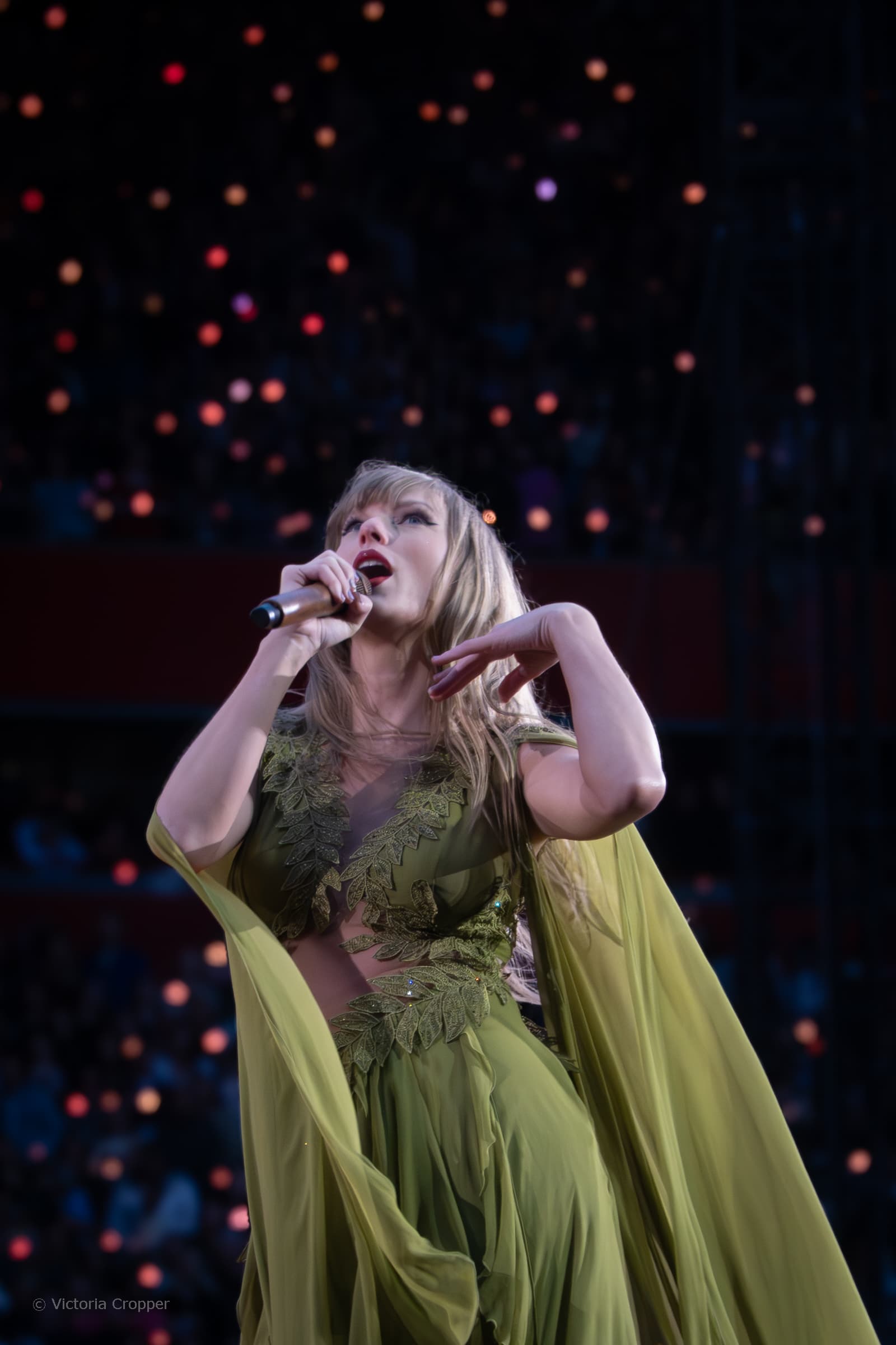 Taylor Swift singing live at Anfield under stage lights.