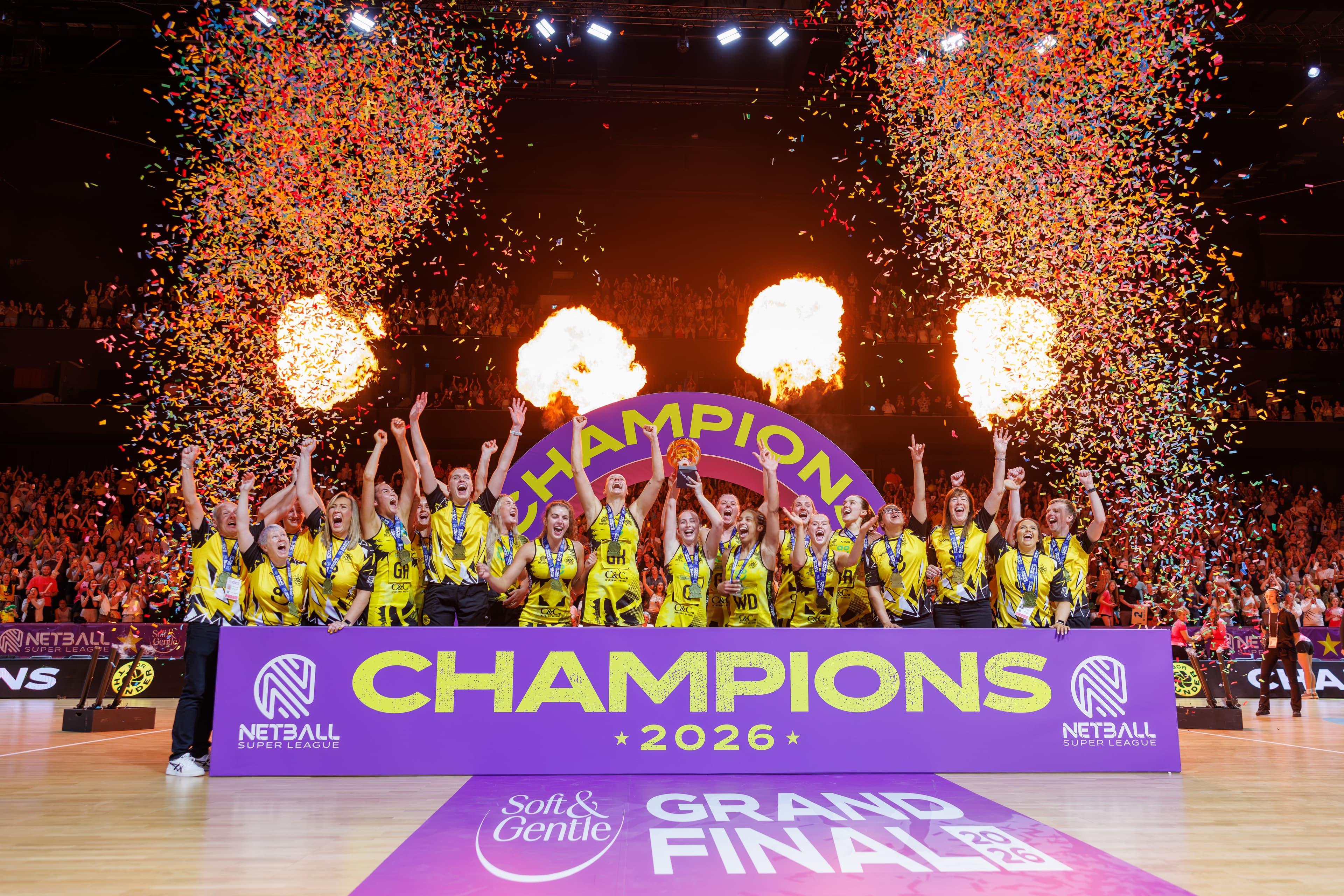 Netball team celebrating as champions beneath pyrotechnics at the 2026 Netball Super League Final.