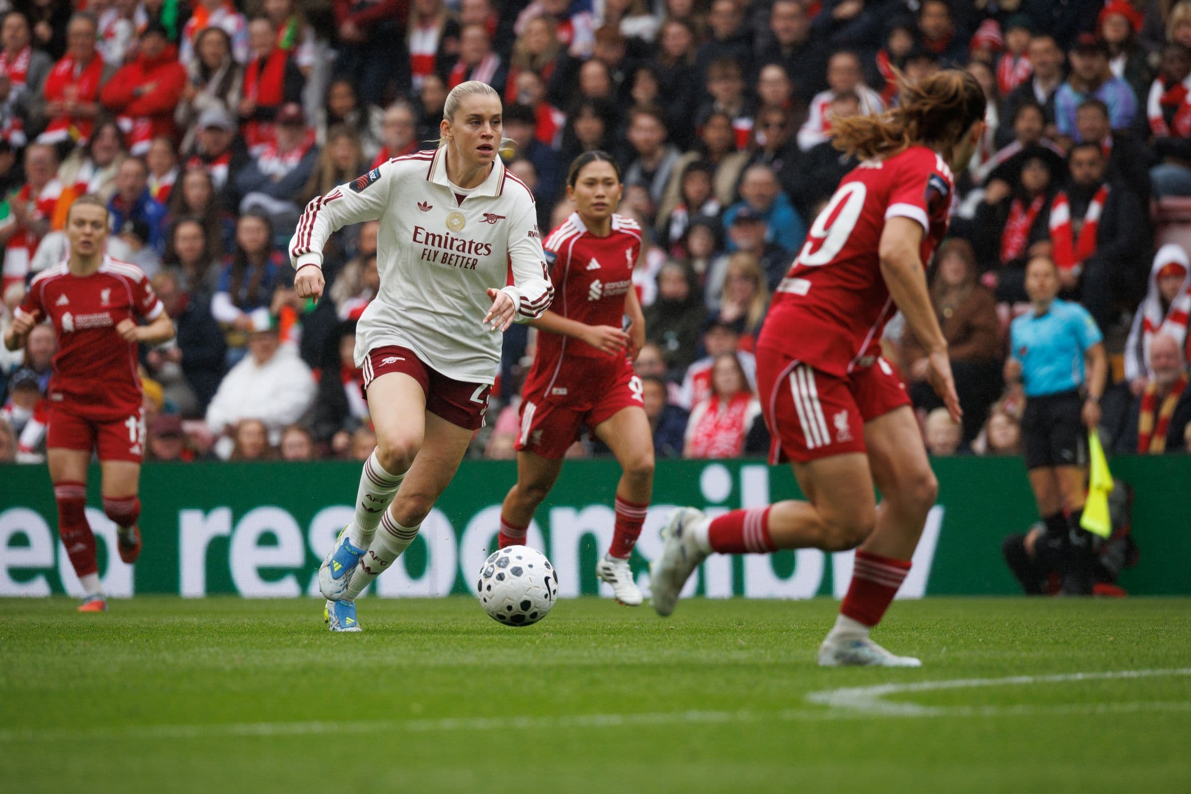 Footballer advancing with the ball during a live match.