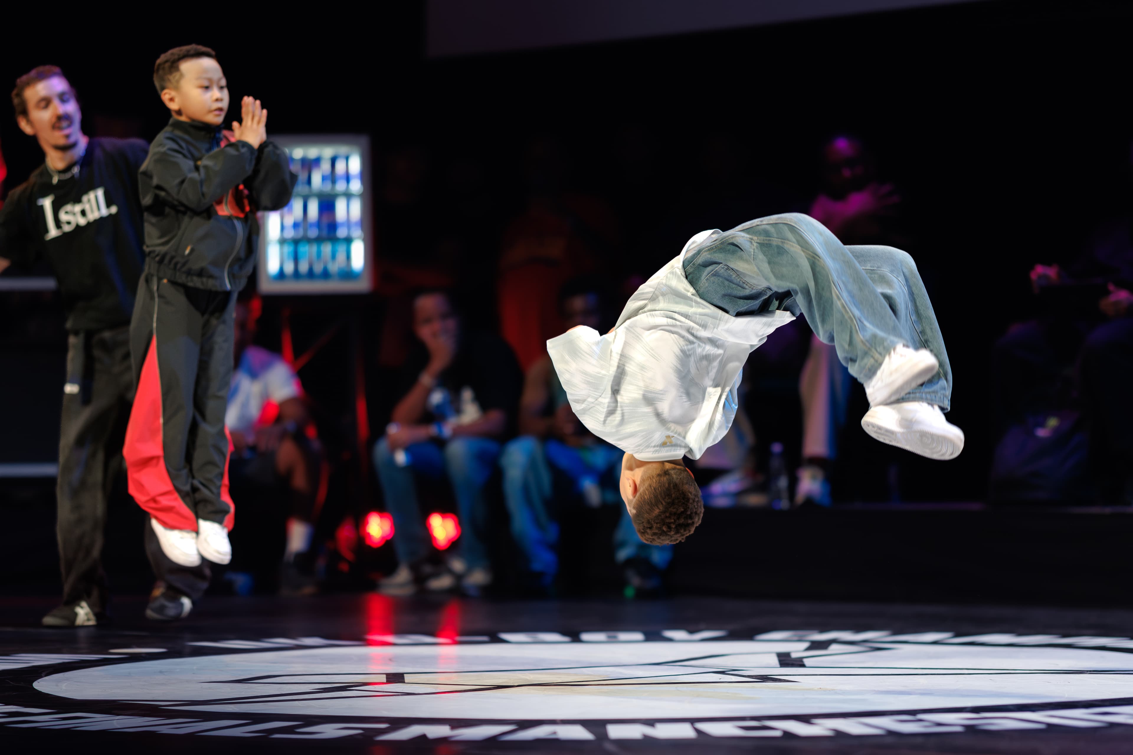 A breaker airborne above the stage during the Breaking Finals.
