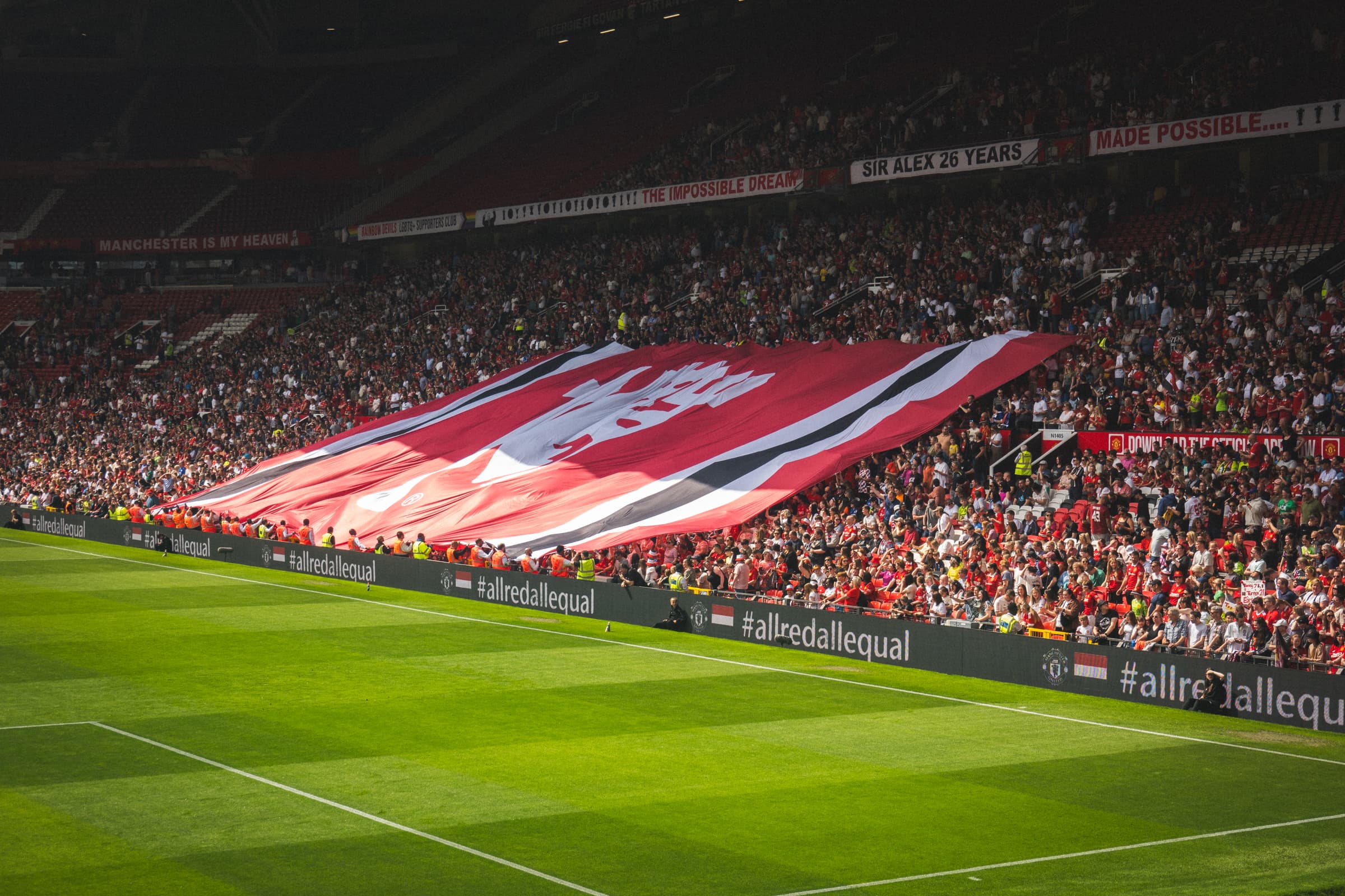 A football stadium with a large supporter display across the stand during a live match.