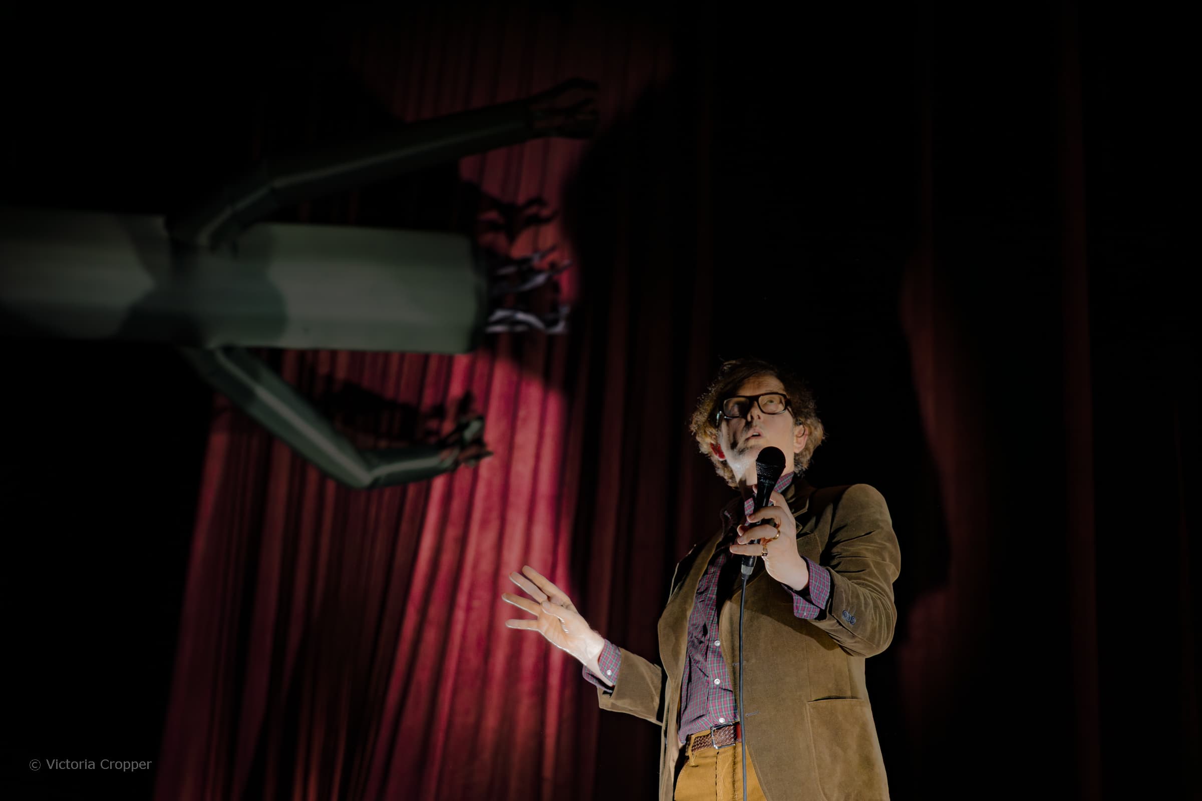 Pulp performing on stage at Co-op Live in Manchester with monochrome screen visuals behind them.