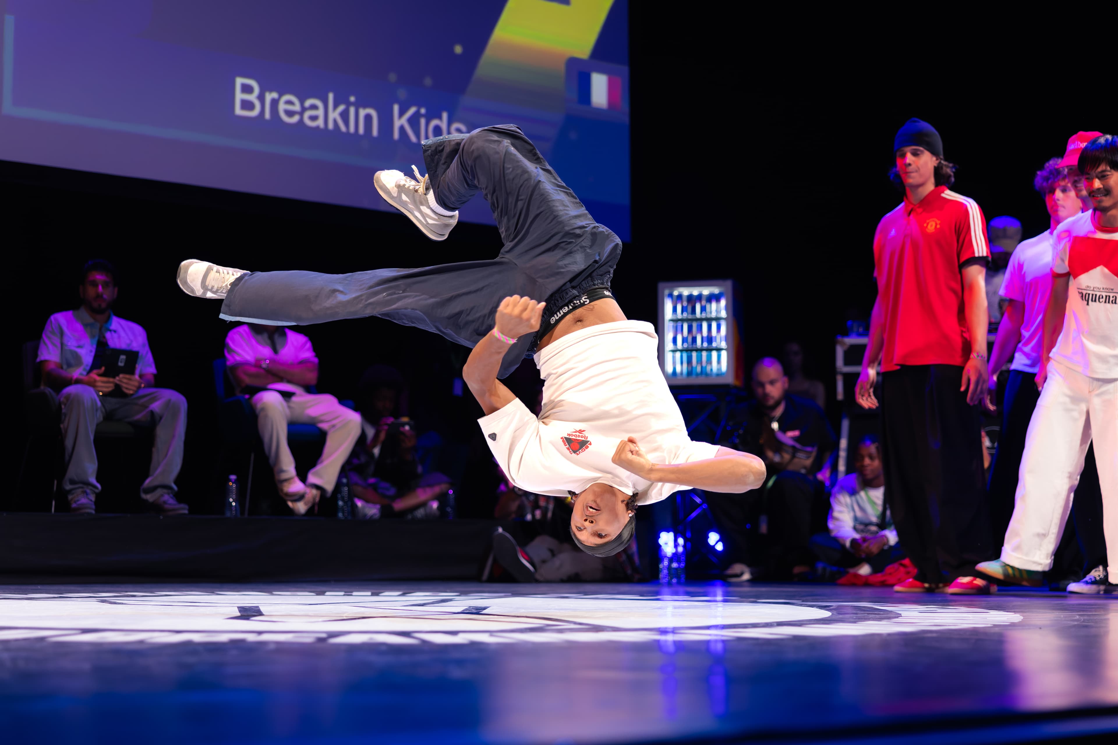 A breaker spinning low across the stage during the Breaking Finals.